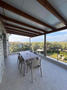 a patio with a table and chairs on a balcony at Iris Villas Complex in Lefkada