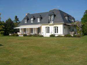 a large white house with a large yard at L'Oisette in Epiniac