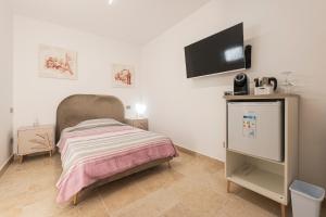 a small bedroom with a bed and a flat screen tv at B&B di MARE in Orta Nova