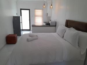 a large white bed in a room with a kitchen at Ultimate Grace in Pretoria