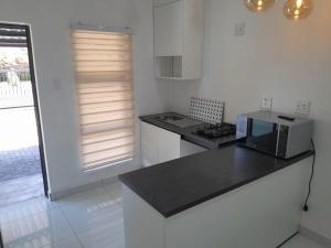 a kitchen with a black counter top and a microwave at Ultimate Grace in Pretoria +11 photos
