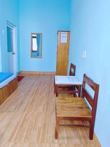 a room with a table and a bench and a blue wall at Bọt Biển Homestay Mũi Né in Ấp Khánh Phước (1)