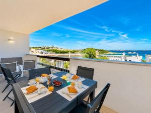 a dining room with a table and chairs on a balcony at Renew Terrace RB Two Bedroom 50m from the Beach in Baja Sardinia
