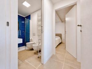 a white bathroom with a toilet and a sink at Renew Terrace RB Two Bedroom 50m from the Beach in Baja Sardinia