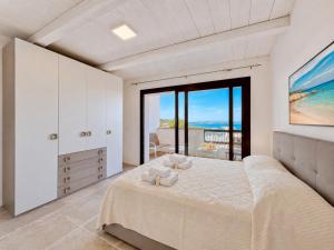a bedroom with a large bed and a large window at Renew Terrace RB Two Bedroom 50m from the Beach in Baja Sardinia