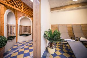 a room with chairs and a table and a plant at AktiVital Hotel in Bad Griesbach