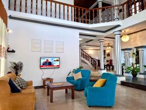 a living room with blue chairs and a tv at Yahana Beach Villa in Negombo