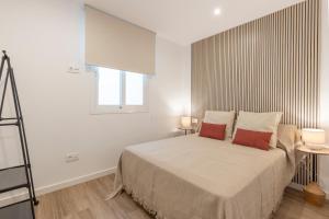 a bedroom with a bed with two red pillows at BiBo Suites Casa Nawal in Granada