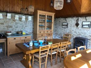 a kitchen with a wooden table and wooden chairs at L'école buissonnière chambres et table d'hôtes in La Celle-Dunoise