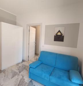 a blue couch in a white living room at Dolce Luna in Isola Sacra