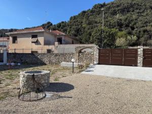 a yard with a house and a fence and a building at Family villa con terrazza e relax in Pietra Ligure