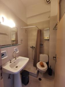 a white bathroom with a sink and a toilet at Μπαλκόνι Στο Γαλάζιο in Agios Georgios