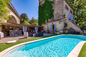 an outdoor swimming pool in front of a house at Chambre D'hôtes Le Moulin in Balaruc-le-Vieux