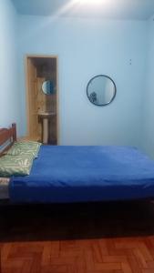 a bedroom with a blue bed with a blue wall at Hotel Flamingos in Santos