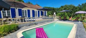 a swimming pool in front of a house at Gîte-La mare aux étoiles in La Douze