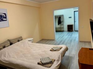 a bedroom with a bed with two towels on it at Basarab Residence Urban Comfort Apartment in Râșcani in Chişinău