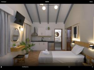 a bedroom with a white bed and a kitchen at Villa Apollo in Parga