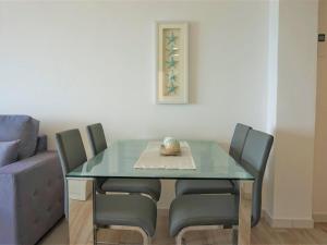 a dining room table with four chairs and a glass table at La perla del mar 2 in Son Servera