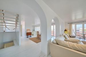 a white living room with a couch and a dining room at Casa Branca - Caparica in Charneca