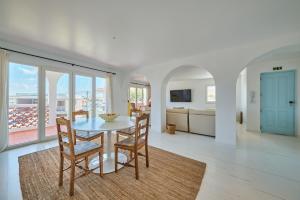 a kitchen and dining room with a table and chairs at Casa Branca - Caparica in Charneca