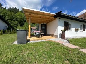 a small white house with a wooden patio at Tiroler Bergchalet bei Kitzbühel in Kirchdorf in Tirol