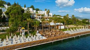 a dock with chairs and umbrellas on the water at Başka Resort Bodrum in Bodrum City