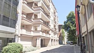 a white building with balconies on a street at Lux 2 Central Apartment with Garage in Plovdiv
