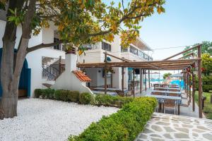 a view of a building with tables and chairs at Kamari Beach Hotel in Potos