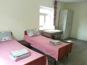a room with two beds and a table with a window at Special Guest House in Zugdidi