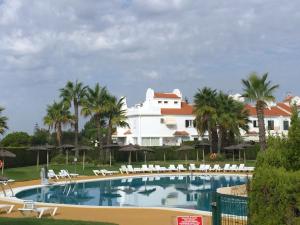 a view of a resort with a swimming pool and palm trees at Los Enebros in Cartaya