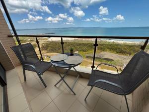 a balcony with a table and chairs and the ocean at Infinity Sea View Deluxe Apartment in Pomorie +6 photos