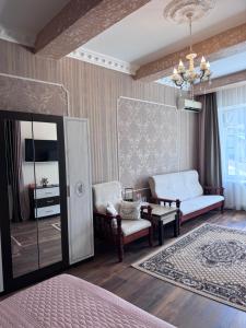 a bedroom with a bed and a chair and a mirror at Liders17 in Odesa
