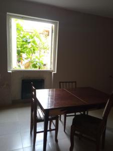 a dining room table with two chairs and a window at large bedroom with two separate beds in Zugdidi