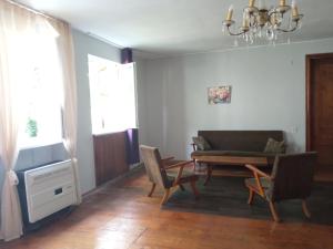 a living room with a couch and chairs and a table at large bedroom with two separate beds in Zugdidi +9 photos