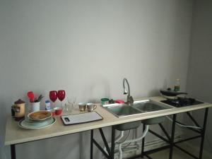 a kitchen with a sink and a counter with dishes at large bedroom with two separate beds in Zugdidi