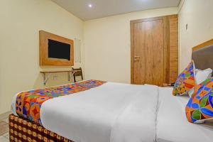 a bedroom with a large white bed and a wooden door at Via Maahi Residency in Mumbai