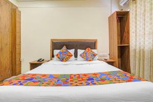 a bedroom with a bed with colorful sheets and pillows at Via Maahi Residency in Mumbai