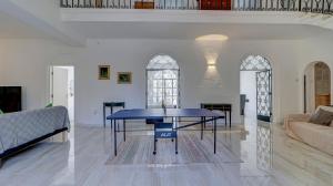 a living room with a table and a couch at Stunning villa w Private pool TT table Sleeps 14 in St. Julianʼs
