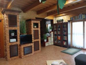 a living room with wooden walls and a tv at Mangó Vendégház in Balatonszárszó