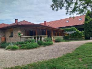 a house with a porch and a driveway at Mangó Vendégház in Balatonszárszó