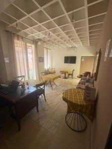 a living room with tables and chairs and a tv at Terrazza Partenopea in Naples
