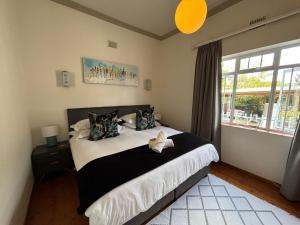 a bedroom with a large bed and a window at Swellengrebel Nest in Swellendam
