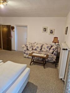 a living room with a couch and a table at Hotel Garni Tonihof in Eschenlohe +2 photos