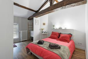 a bedroom with a large red bed with red pillows at Chambres D'hôtes Chapetit in Saint-Denis-de-Pile