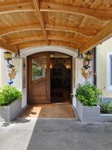 an entrance to a house with a wooden door at Hotel Garni Tonihof in Eschenlohe