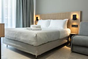 a bedroom with a large bed and a chair at Olympus Jankaea in Paralia Katerinis +56 photos