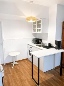a kitchen with a white counter and a table at Independent 2-room apartment in Senhora da Hora