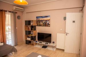 a living room with a flat screen tv on a wall at Stylida Apartment - Ocean Air & Quiet Nights! in Stilís