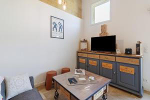 a living room with a tv and a coffee table at Chambres D'hôtes Chapetit in Saint-Denis-de-Pile