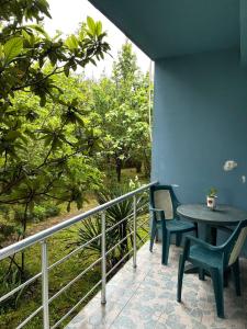 a patio with two chairs and a table on a balcony at Wooden Cottage in Makhinjauri